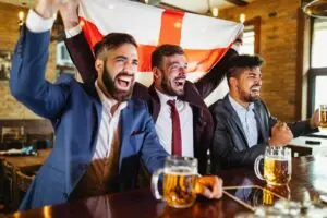 Business men in pub cheering for a sporting event