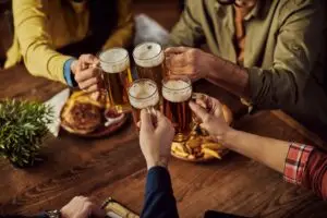 Close-up of friends toasting with beer in a pub.