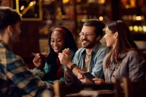 Multiracial group of happy friends talking in a pub.